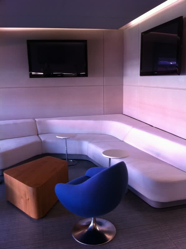 Sala lounge con sillón corrido y sillón azul