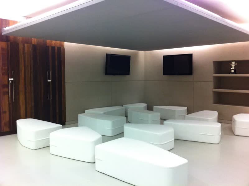 Sala lounge con sillones blancos y lambrín de madera